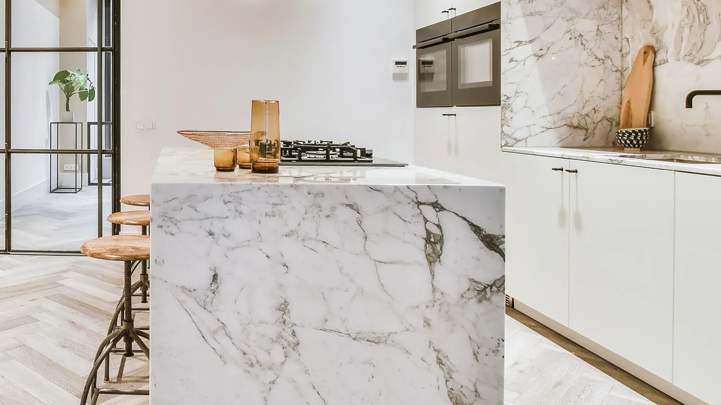 Bright modern kitchen with a dramatic marble waterfall island