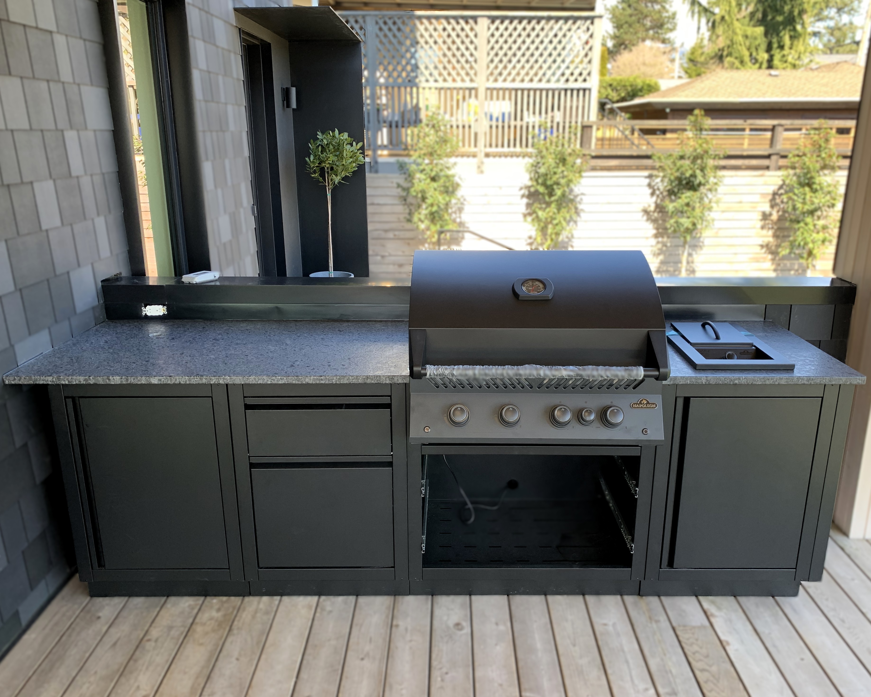 Outdoor kitchen with natural stone countertops and a built-in barbecue